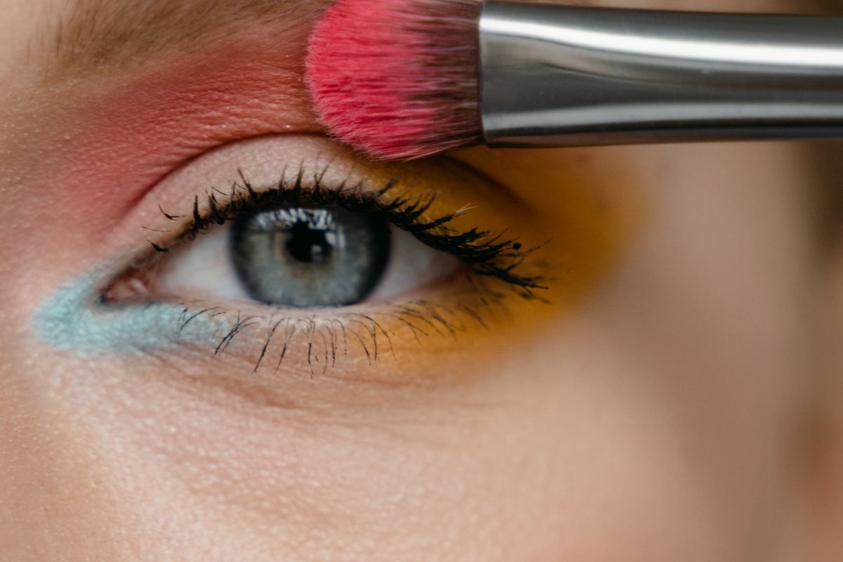 Cream blush being blended upward on a cheek with fingers