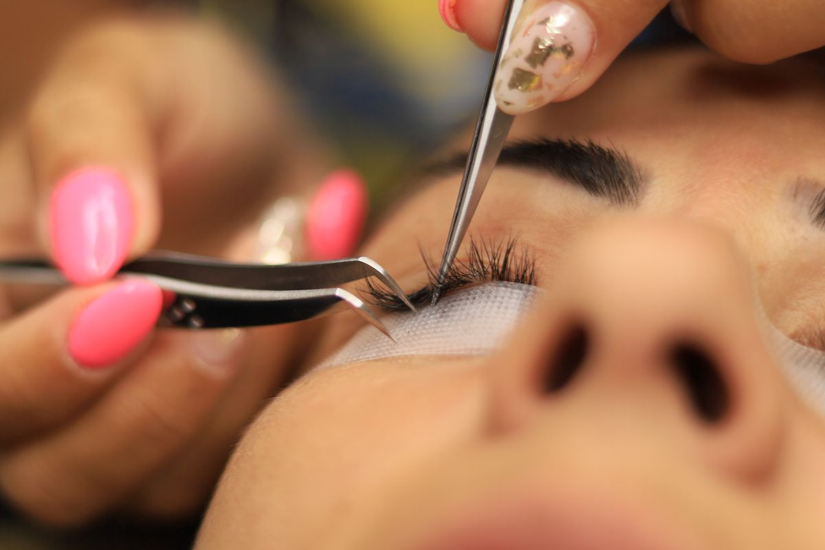 Brow pencil, tinted gel, pomade, and spoolie arranged on a plain surface