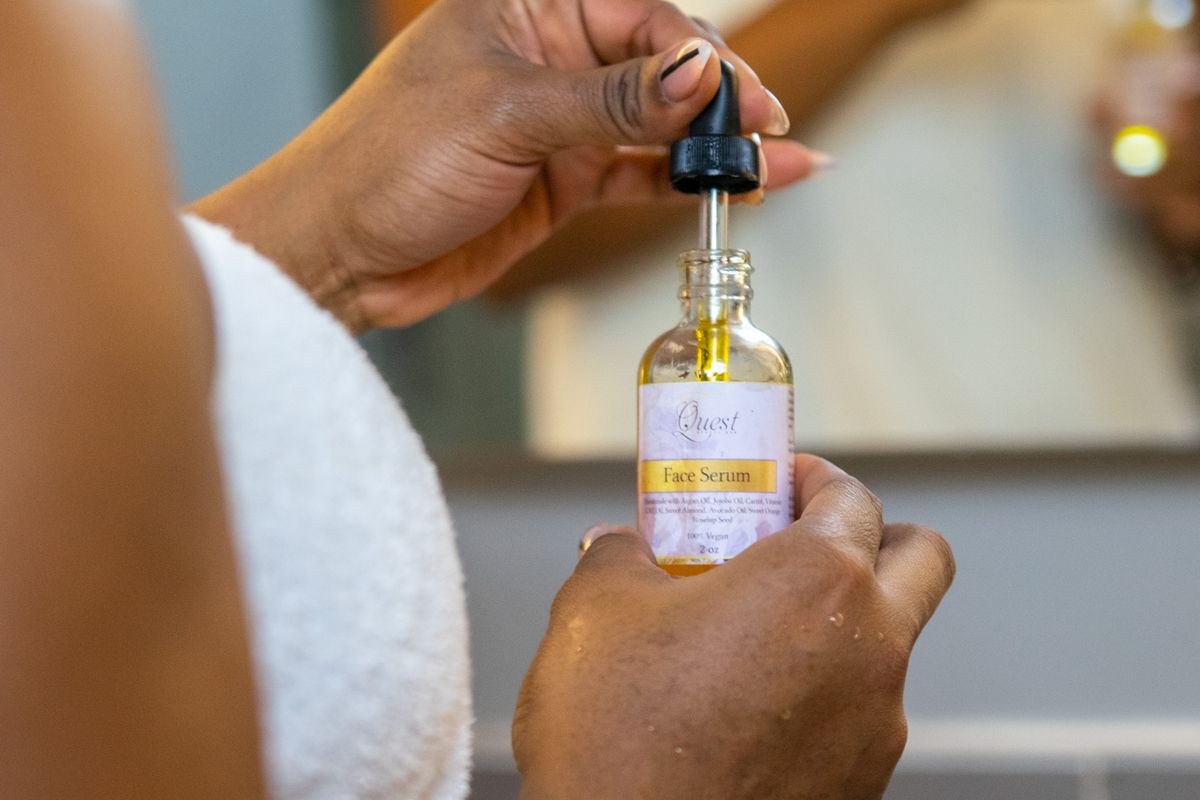 Clear hyaluronic serum drops between a pipette and a glass dish