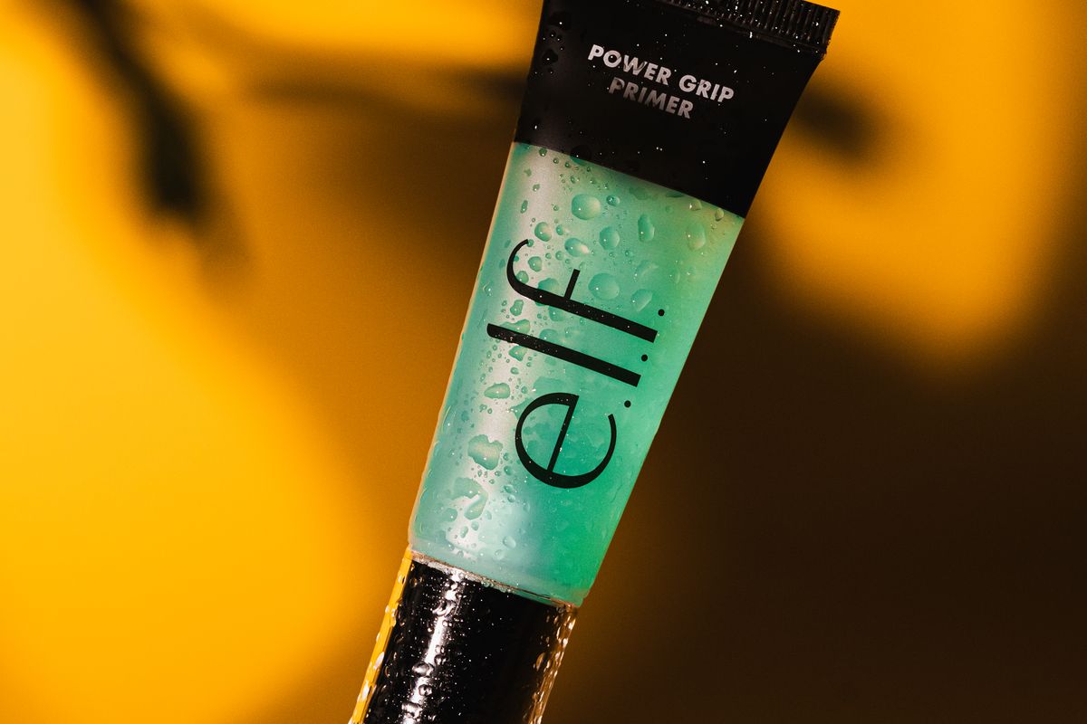 A small serum bottle on a plain surface with its ingredient label facing forward